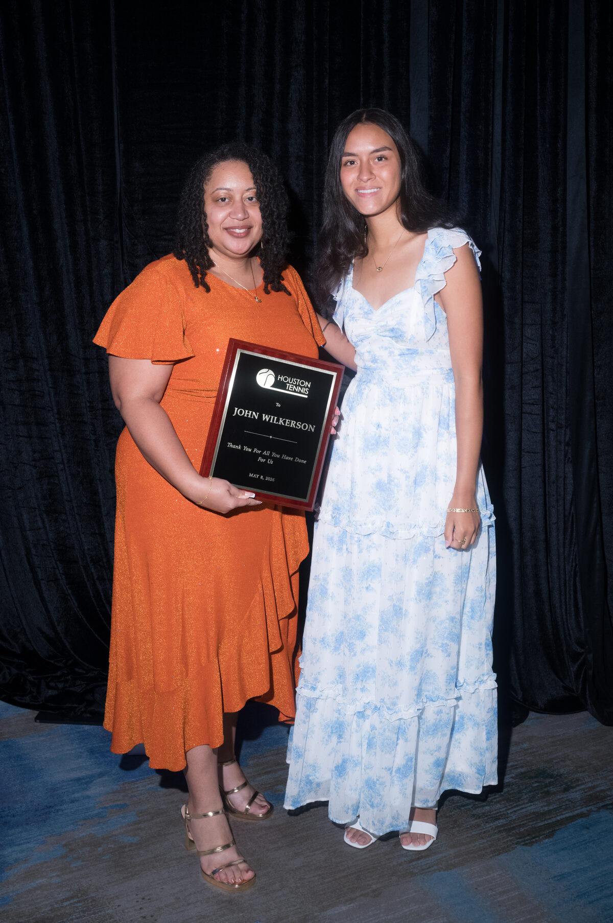 Kelly Wilkerson holding the plaque honoring her father, John Wilkerson